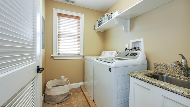 laundry area with light tile patterned flooring, sink, washing machine and clothes dryer, and a healthy amount of sunlight