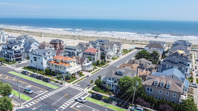 bird's eye view with a water view and a beach view