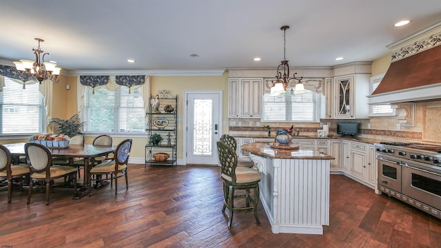 kitchen featuring decorative light fixtures, dark hardwood / wood-style flooring, a center island, and range with two ovens