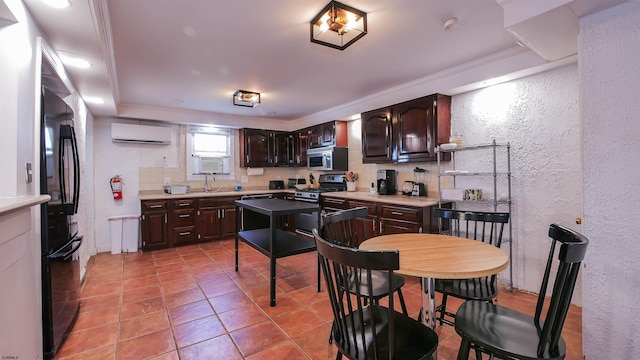 kitchen featuring a wall mounted air conditioner, stainless steel microwave, tasteful backsplash, freestanding refrigerator, and dark brown cabinetry