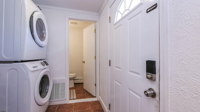 washroom with visible vents, laundry area, stacked washer and clothes dryer, a baseboard heating unit, and crown molding