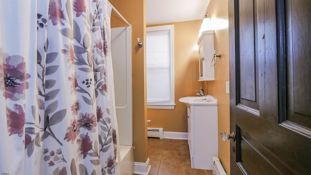 full bath with a baseboard heating unit, tile patterned floors, vanity, and baseboards