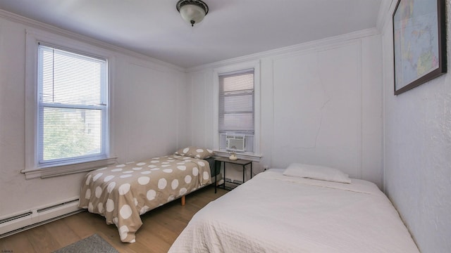 bedroom featuring a baseboard heating unit and wood finished floors