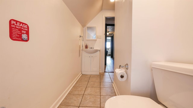 bathroom with toilet, lofted ceiling, tile patterned flooring, baseboards, and vanity