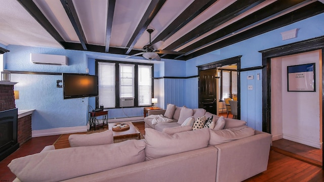 living area with ceiling fan, beam ceiling, a textured wall, and a wall mounted AC