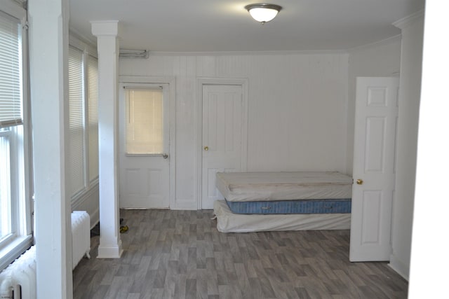 unfurnished bedroom featuring dark hardwood / wood-style flooring, radiator heating unit, and crown molding