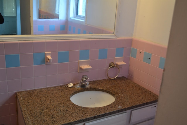 bathroom featuring vanity and tile walls