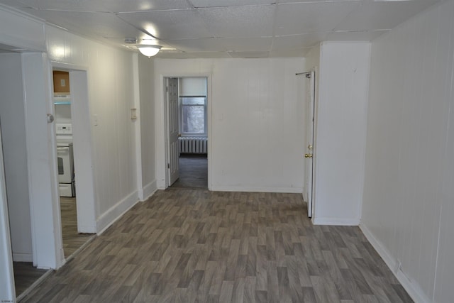 corridor featuring a paneled ceiling, dark hardwood / wood-style flooring, and radiator heating unit