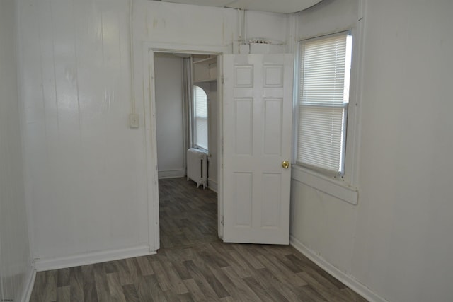 spare room with radiator and dark wood-type flooring