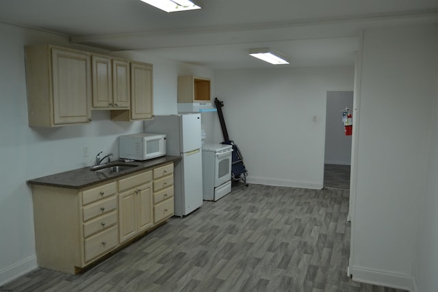 kitchen with light hardwood / wood-style floors, white appliances, and sink