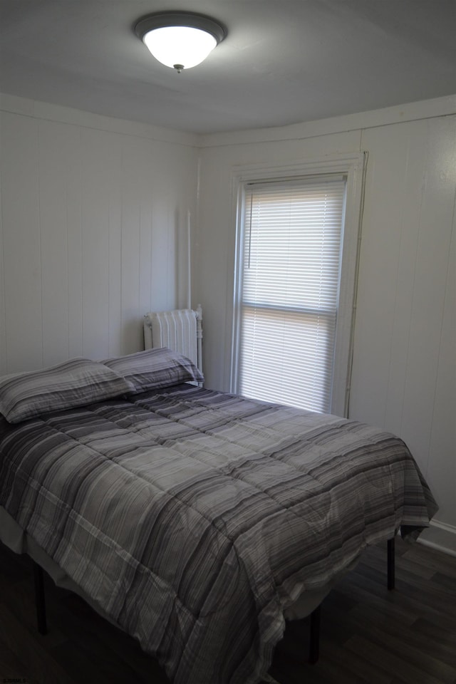 bedroom featuring hardwood / wood-style floors and wood walls