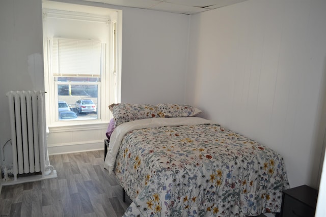 bedroom with hardwood / wood-style flooring and radiator