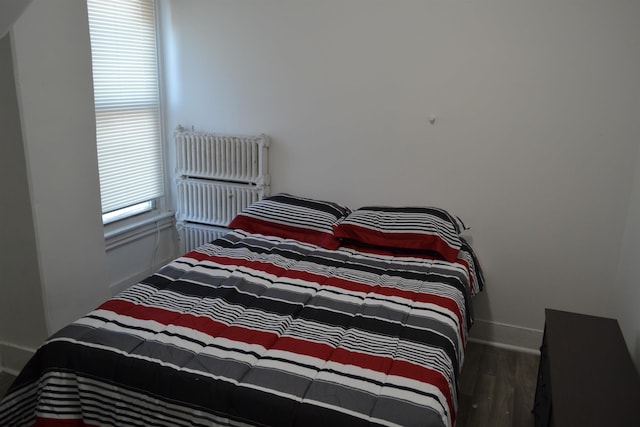 bedroom featuring dark hardwood / wood-style flooring and radiator heating unit