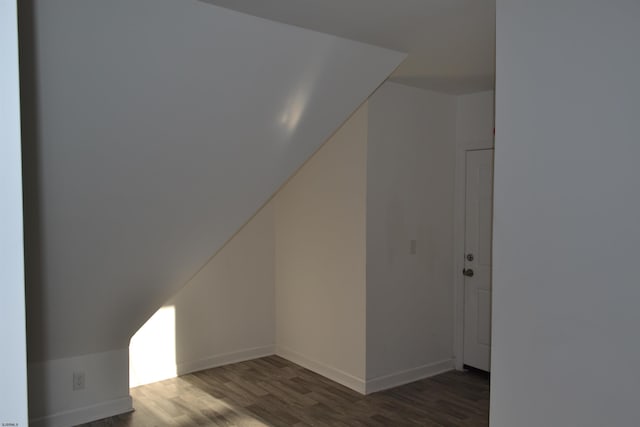 bonus room with dark wood-type flooring and lofted ceiling