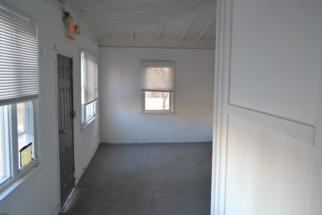 empty room with lofted ceiling with beams