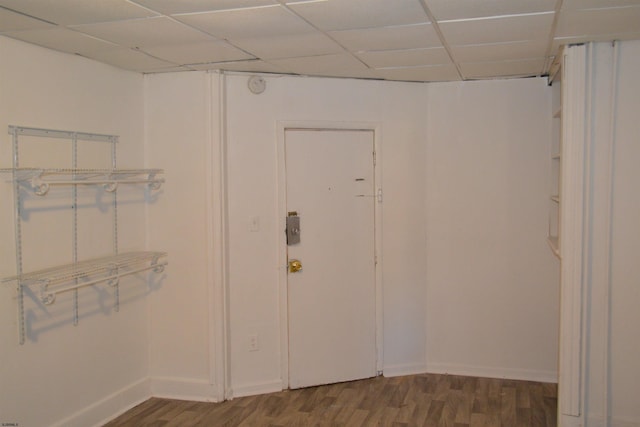 interior space featuring a drop ceiling and dark wood-type flooring