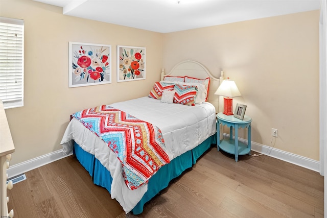 bedroom with baseboards and wood finished floors