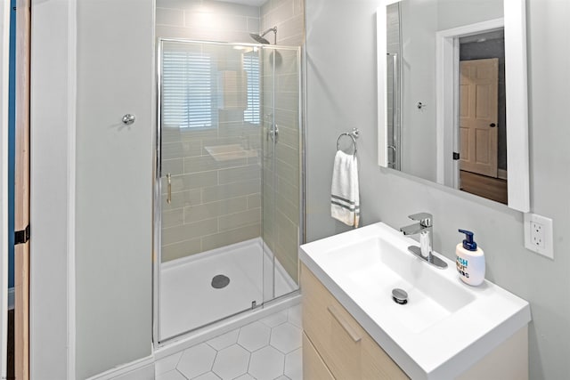 bathroom with tile patterned floors, a shower stall, and vanity