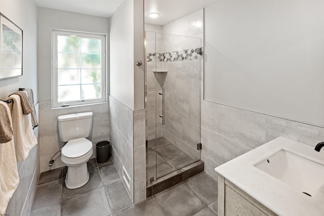 full bathroom featuring a wainscoted wall, tile walls, toilet, a shower stall, and tile patterned floors