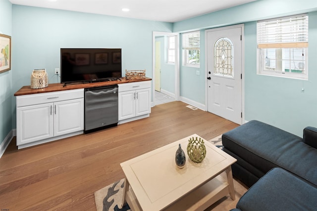 living room featuring baseboards, light wood finished floors, visible vents, and recessed lighting