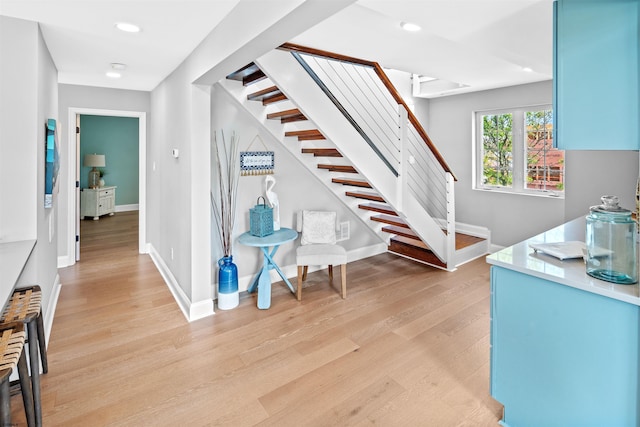 stairway featuring recessed lighting, baseboards, and wood finished floors