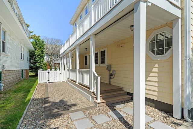 exterior space with covered porch and a gate