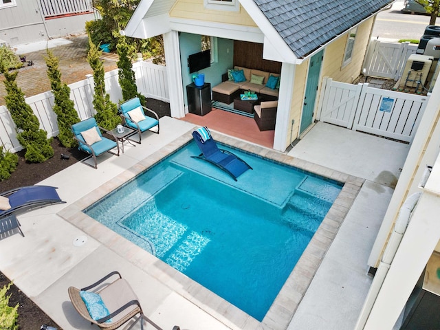 view of swimming pool featuring a gate, fence, outdoor lounge area, and a patio