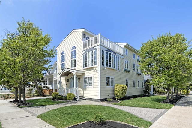 view of front of home featuring a front yard and a balcony