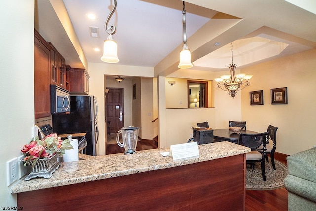 kitchen with visible vents, dark wood finished floors, a raised ceiling, appliances with stainless steel finishes, and light stone countertops