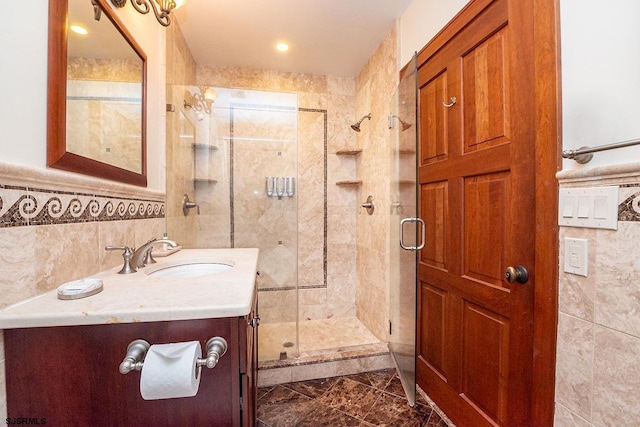 bathroom featuring a stall shower, tile walls, and vanity