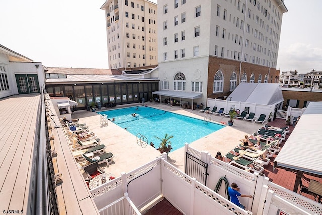 community pool featuring fence and a patio