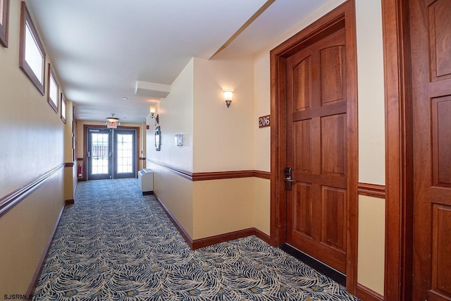 hall featuring carpet, french doors, baseboards, and radiator heating unit