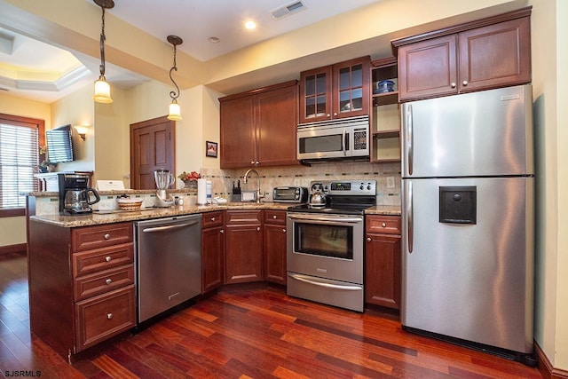 kitchen with a peninsula, visible vents, stainless steel appliances, and dark wood finished floors