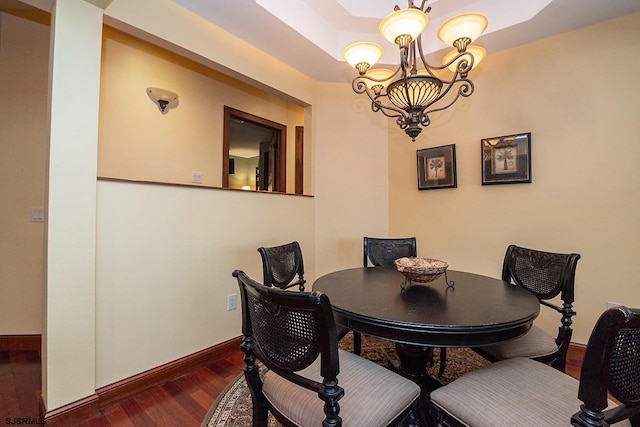 dining room featuring a chandelier, baseboards, and dark wood-style floors