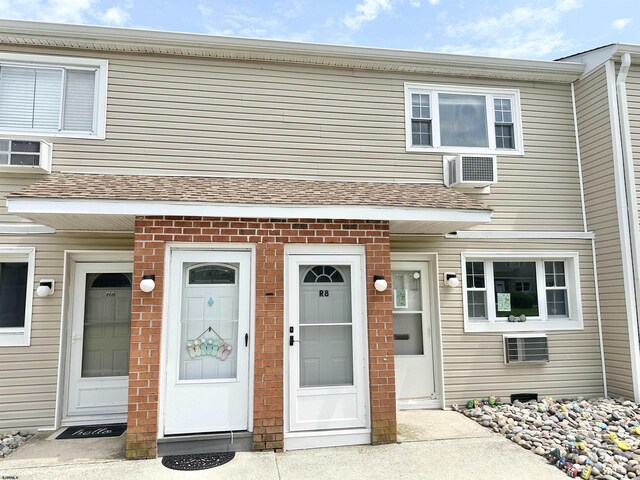 view of front of home with a wall mounted air conditioner