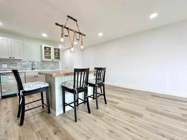 kitchen with light hardwood / wood-style floors, dishwasher, and pendant lighting