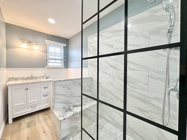 bathroom with vanity, tiled shower, and wood-type flooring