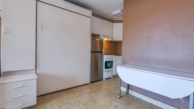 kitchen featuring light tile patterned floors, stainless steel refrigerator, stove, and white cabinetry