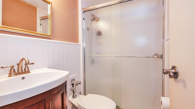 bathroom with toilet, an enclosed shower, and vanity