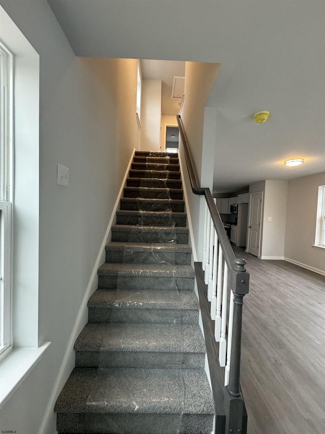 stairway with baseboards and wood finished floors