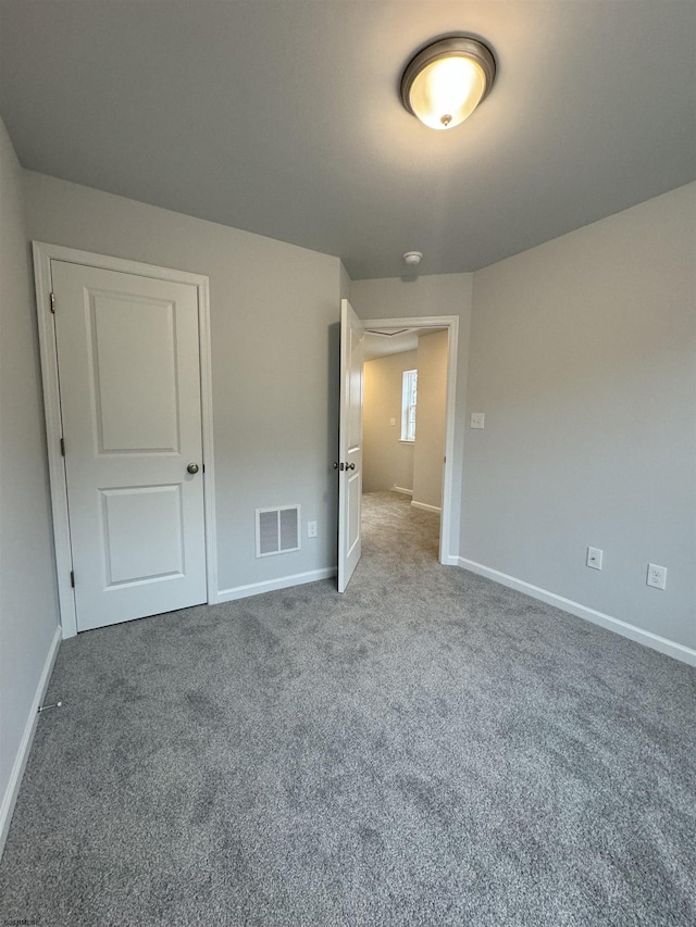 unfurnished bedroom featuring carpet, visible vents, and baseboards