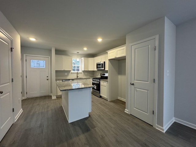 kitchen with white cabinets, dark wood-style flooring, stainless steel appliances, and a sink