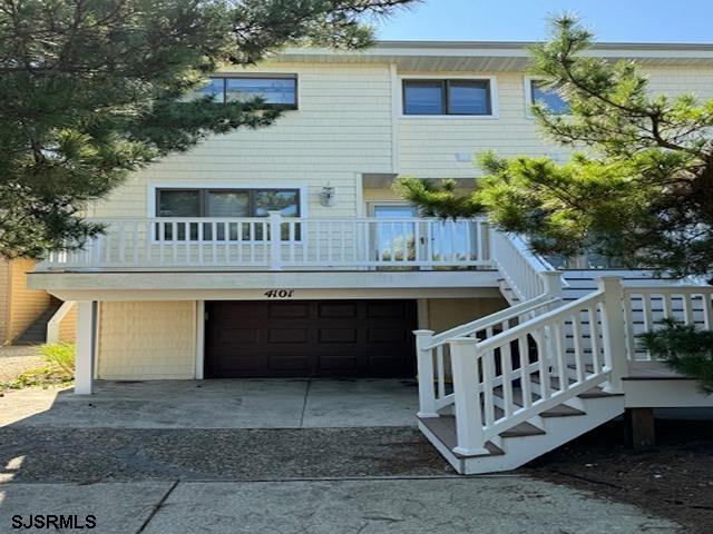 view of front of home featuring a garage, concrete driveway, and stairs