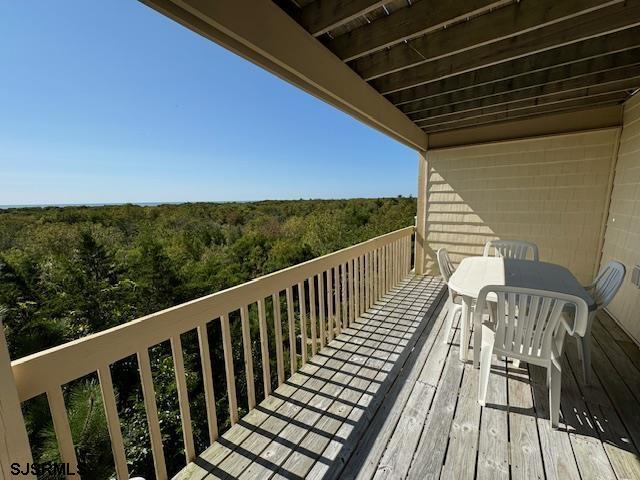 balcony with a forest view and outdoor dining area