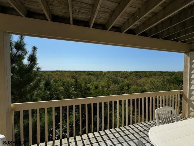 wooden terrace with a wooded view