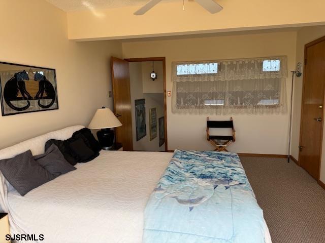 bedroom with ceiling fan, carpet flooring, and baseboards