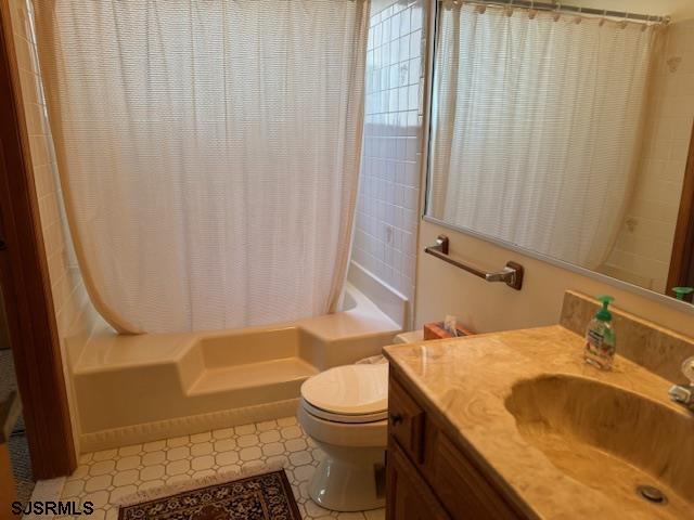 bathroom with shower / bath combo, vanity, and toilet