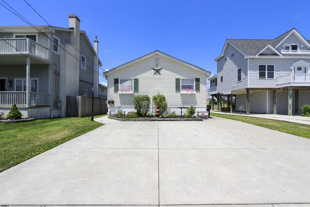 view of front facade featuring a balcony and a front yard