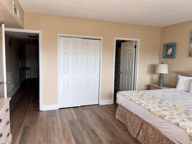 bedroom with a closet, wood-type flooring, and a textured ceiling