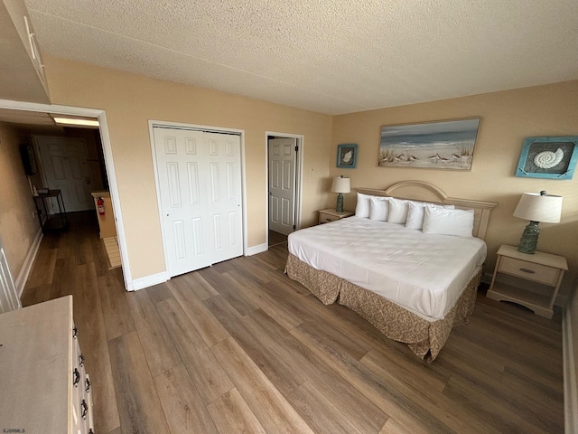 bedroom with hardwood / wood-style floors, a textured ceiling, and a closet